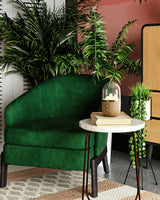 Nursery table lamp lit on a marble table beside a green armchair