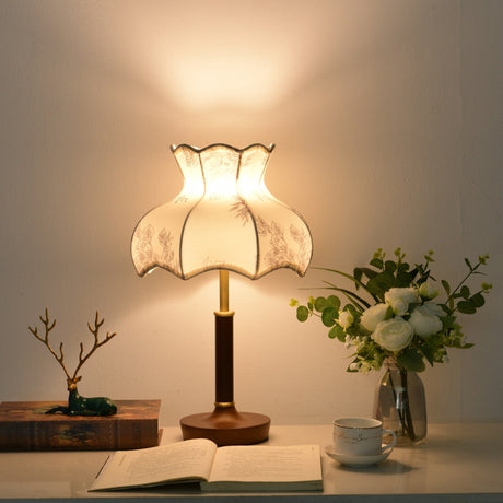 Blossom shade lamp lit warm beside a small bonsai and a teacup