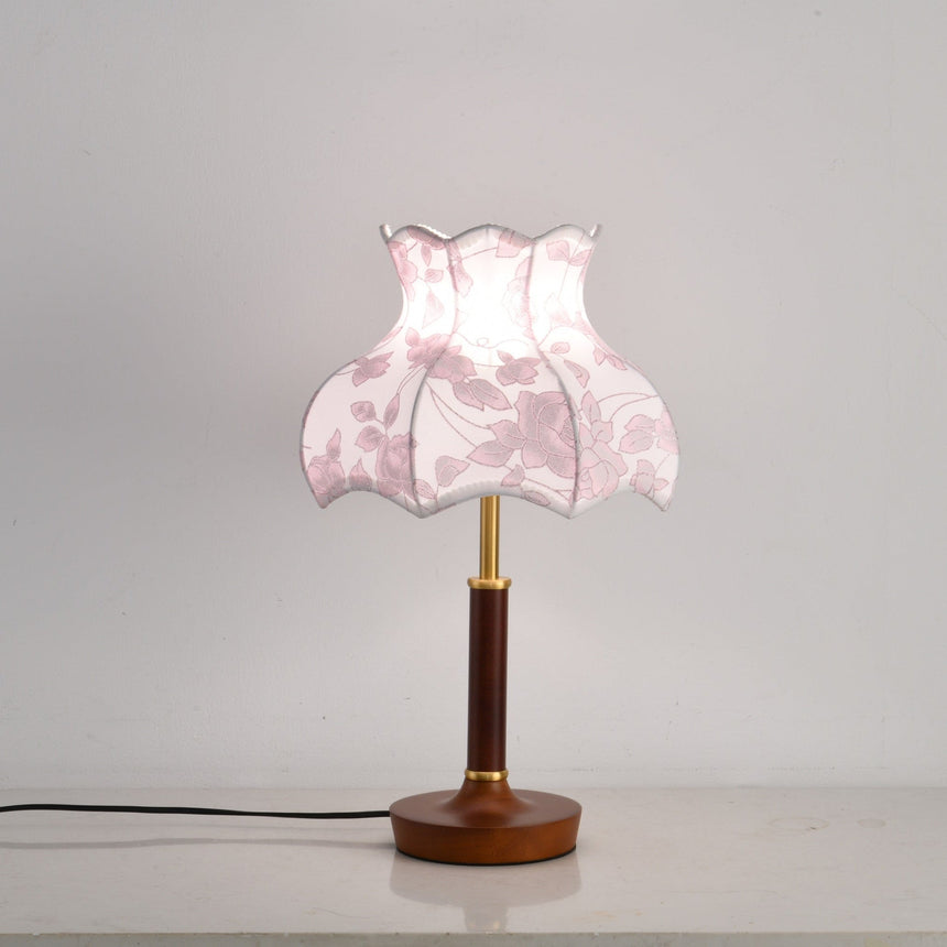 Pink blossom shade lamp lit, the panels glowing softly