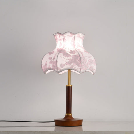 Pink blossom shade lamp on a plain ground with a wood disc base