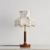 Close view of the scalloped blossom shade and the brass stem below