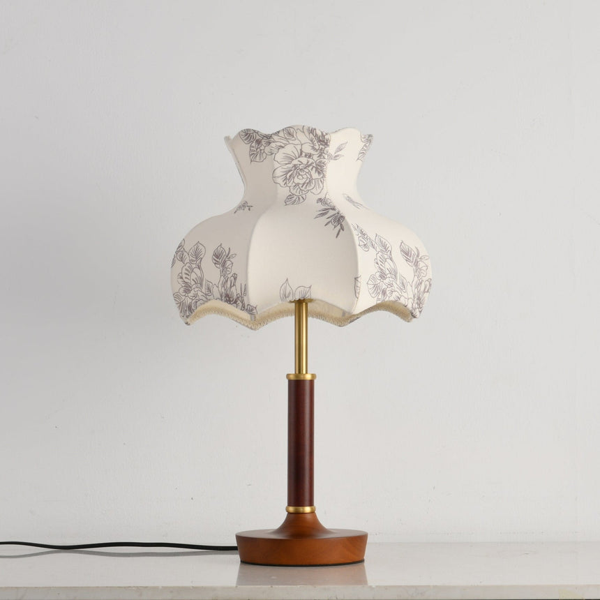 Close view of the scalloped blossom shade and the brass stem below