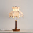 White blossom shade lamp on a plain ground, the wood base below