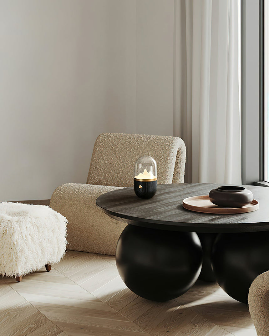 Nursery table lamp lit on a dark coffee table in a pale living room
