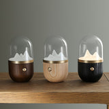 The three finishes of the nursery table lamp lined up on a wooden shelf