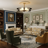 Chandelier lit in a room with a fireplace and two green armchairs