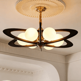 Chandelier lit in a bedroom above a bed with a wood panel wall behind