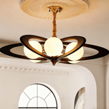 Chandelier lit under a plaster ceiling medallion above a framed print