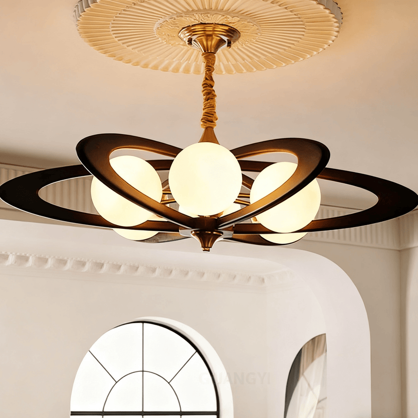 Chandelier lit under a plaster ceiling medallion above a framed print