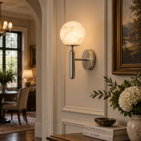 The lit globe beside framed art above a console with white flowers