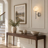 The lit globe above a console with a vase and bowls near a staircase