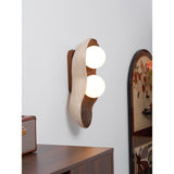Sconce lit beside framed artwork above a console with a small radio