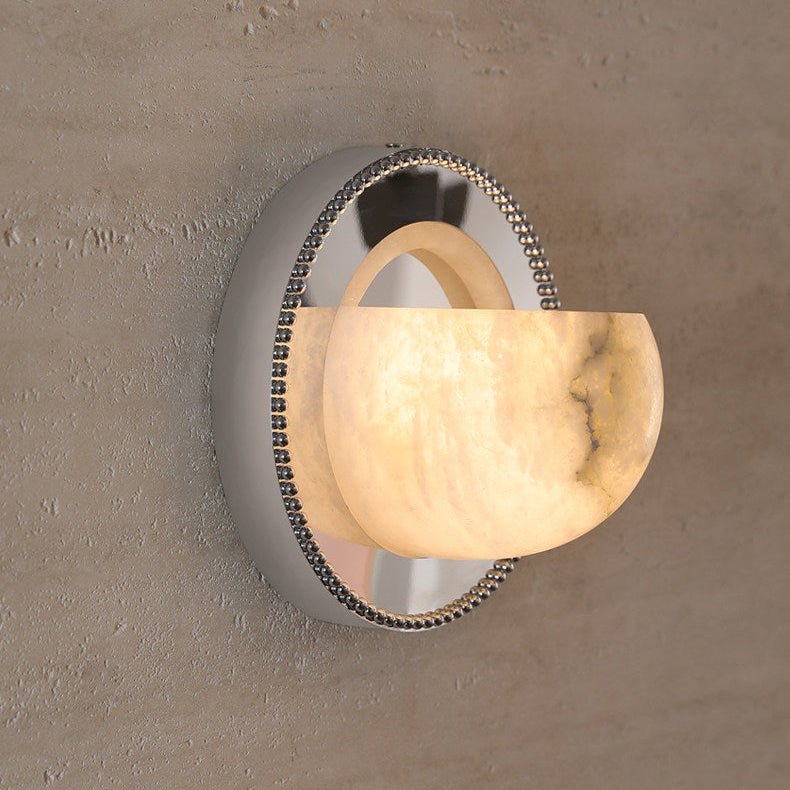 The orbit light lit on a textured plaster wall, the alabaster glowing