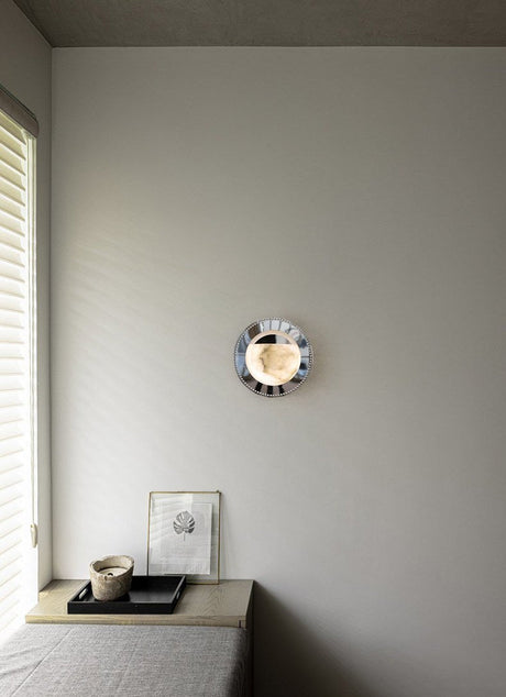 The orbit light lit above a low bench beside a window