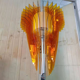 The amber version in daylight, blades fanning out below a pale wood wall