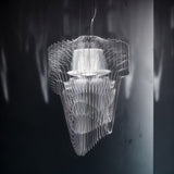 The same flowing form in clear acrylic, its layers radiating from a lit center