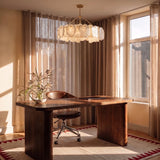 A petal ring lit above a timber desk beside a window and curtains
