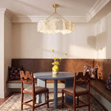 A petal ring lit above a dining table and a leather banquette
