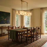 A petal bar lit above a long dining table with timber chairs