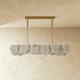 A linear bar of gray stone petals below a brass ceiling plate
