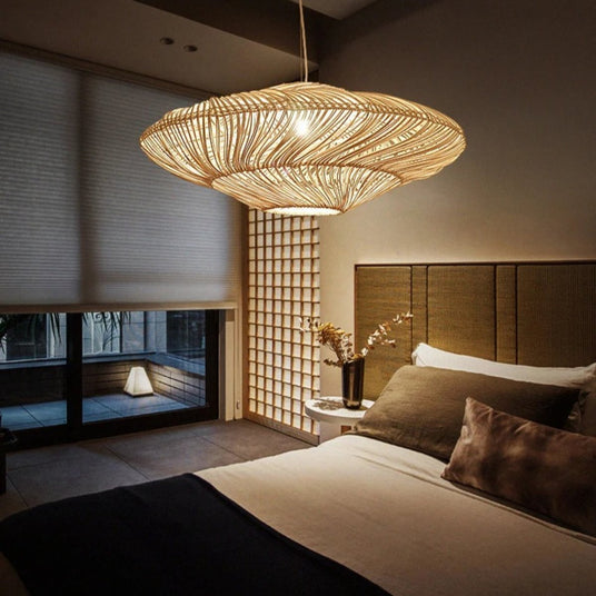 The shade lit above a bed with a wide headboard and a screened window behind