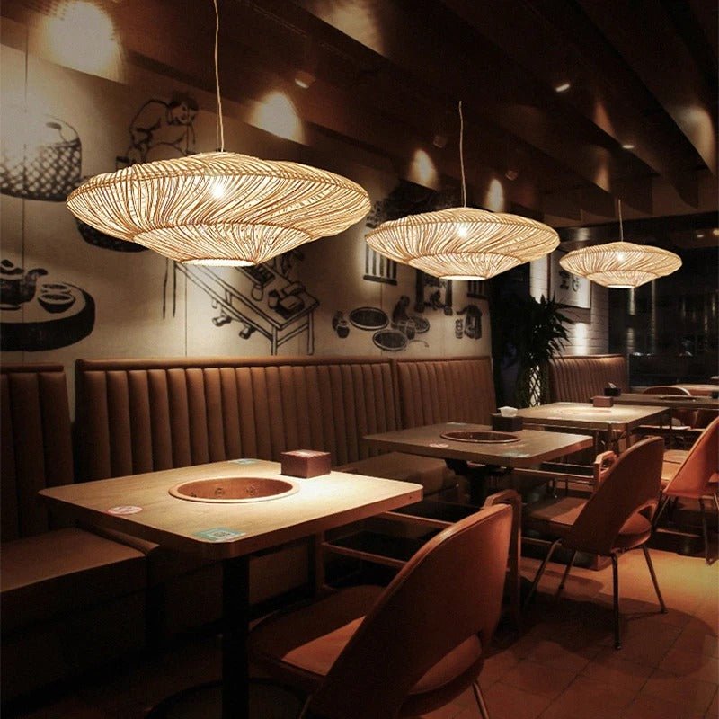 Three of the shades lit in a row above restaurant tables and a curved banquette