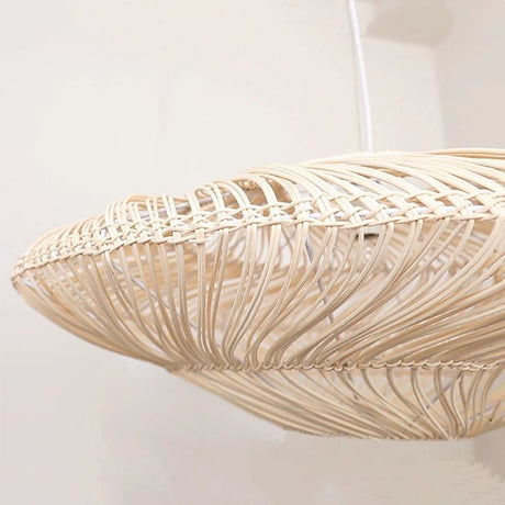 The edge of the shade seen close, the rattan strands bound at the rim