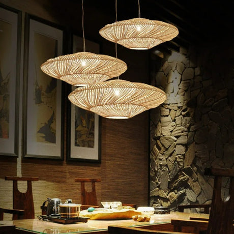 Three shades at different heights lit against a rough stone wall above a table
