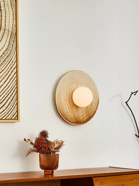 The sconce above a low console beside a framed print