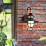 The light on brick with foliage and a window frame in the foreground