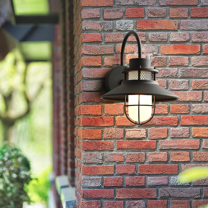 The light on brick with foliage and a window frame in the foreground