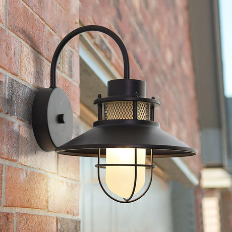 The barn light on a red brick house wall with a window frame beside it