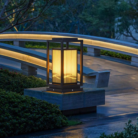 The cage lantern lit beside a curved walkway with a handrail at dusk