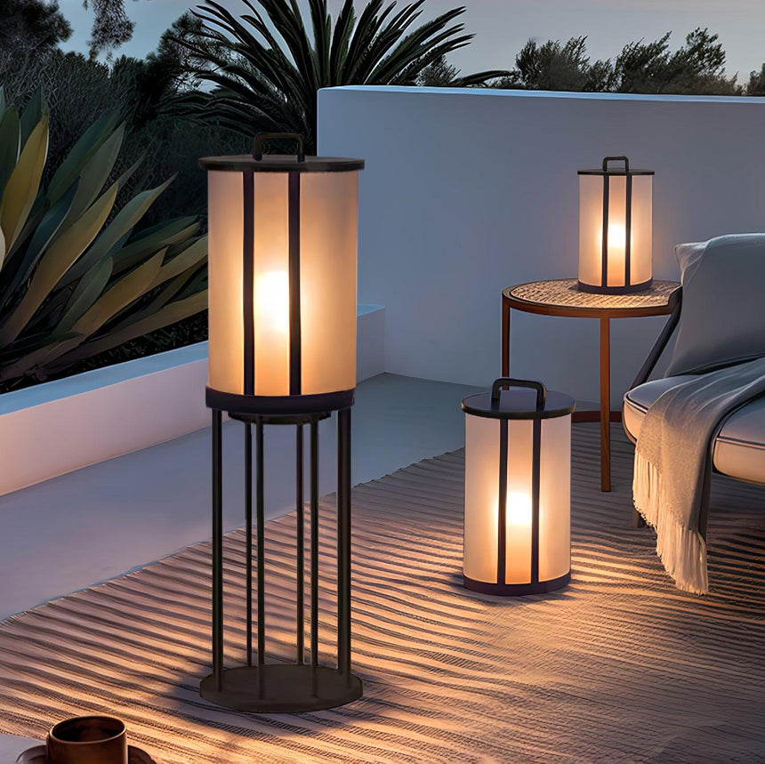 Lanterns lit on a timber deck beside a yucca and a lounger at night