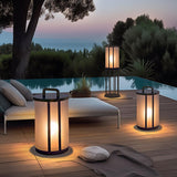 The lantern lit at a pool edge beside a lounger with planting behind