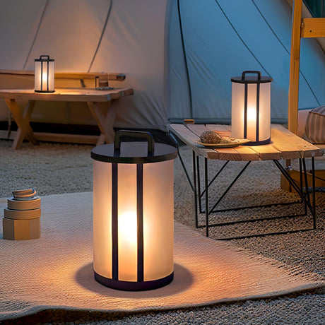 Lanterns lit beside a canvas tent and a side table on a terrace at night