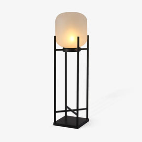 Opal cylinder shade resting in an open square steel stand in black