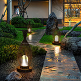 Two lit along a wet stone path with clipped planting either side