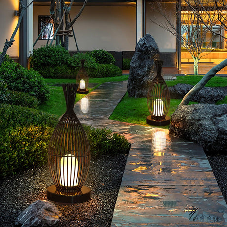 Two lit along a wet stone path with clipped planting either side