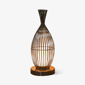 Tall wire cage lantern shaped like a vase with a lit inner cylinder