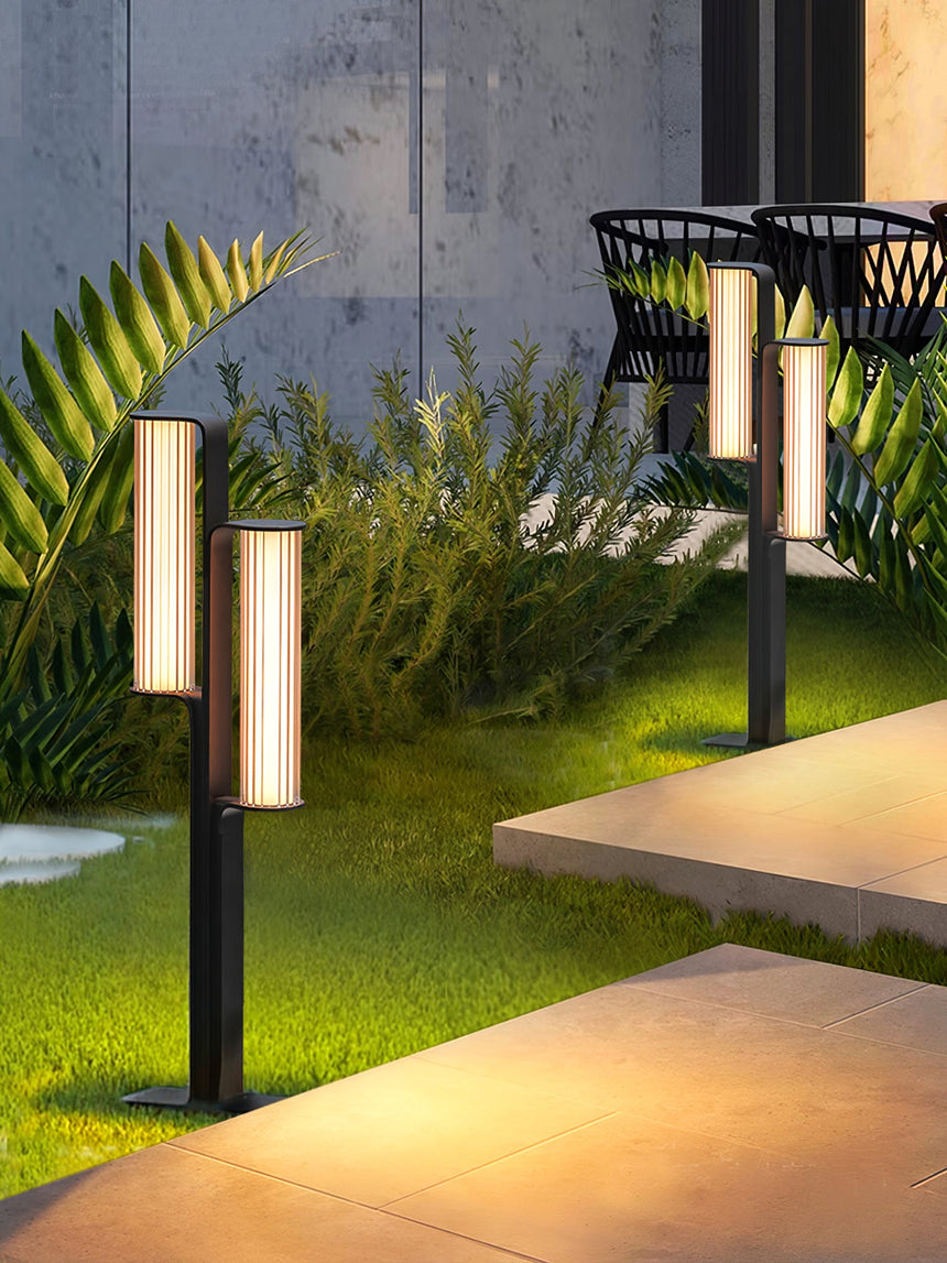 The two arm body lit beside ferns with a dark metal bench behind it
