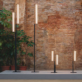 Two heights lit together against a brick wall with potted planting