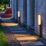 Two lit beside a stepping stone path against a concrete garden wall
