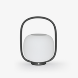 White globe diffuser held inside a black arch handle on a small base