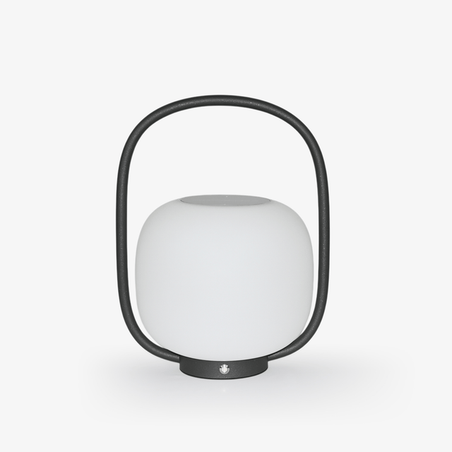 White globe diffuser held inside a black arch handle on a small base