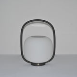The lamp unlit, the matte globe and the arch handle seen in daylight