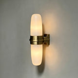 The lit tube glowing warm against a gray wall, bracket in shadow
