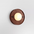 The round walnut plate version with a pale disc set proud of its face