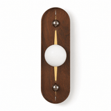 The walnut pill unlit, a pale sphere and a warm slot down the frame