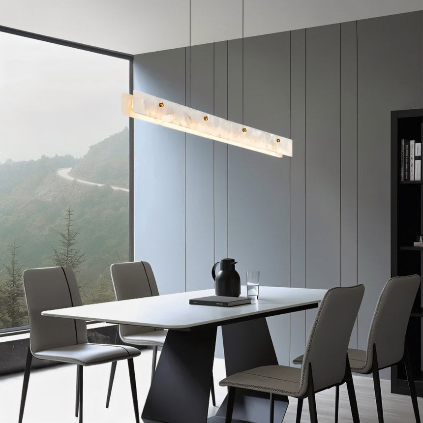 The lit bar above a dining table with chairs and a window onto the hills